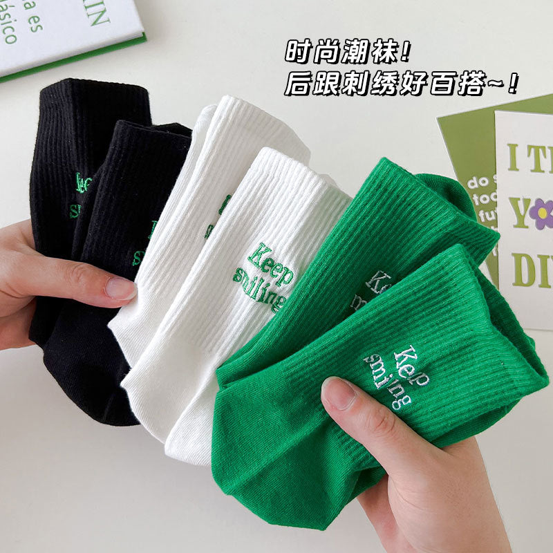 Sock children's winter and autumn ankle-length lettered tube socks in black and white. Women's cotton socks with letter embroidery. Two stripes.