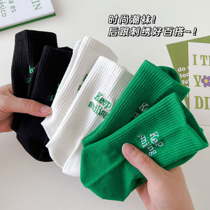 Sock children's winter and autumn ankle-length lettered tube socks in black and white. Women's cotton socks with letter embroidery. Two stripes.
